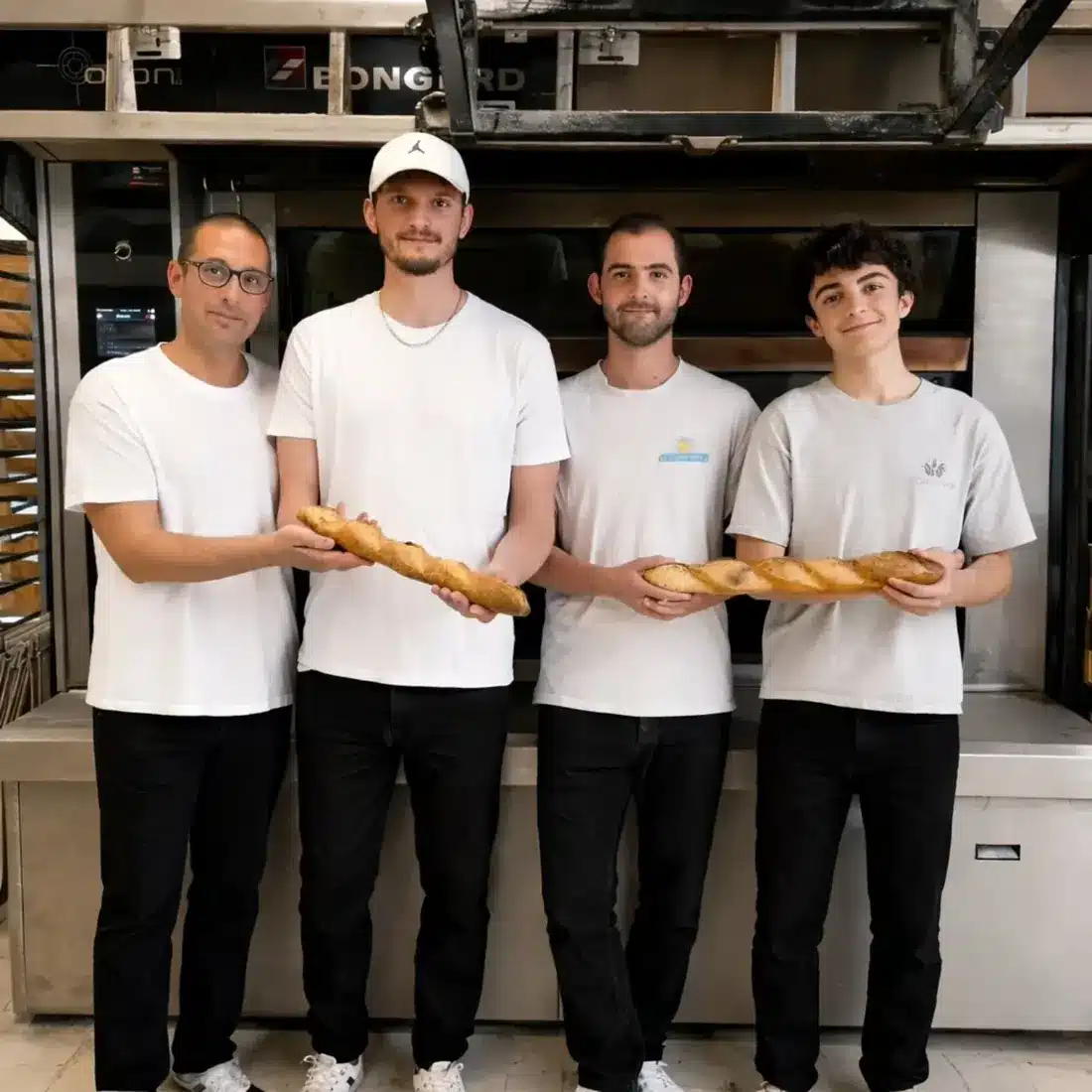 Les boulangers de l'équipe au fournil, baguettes en main