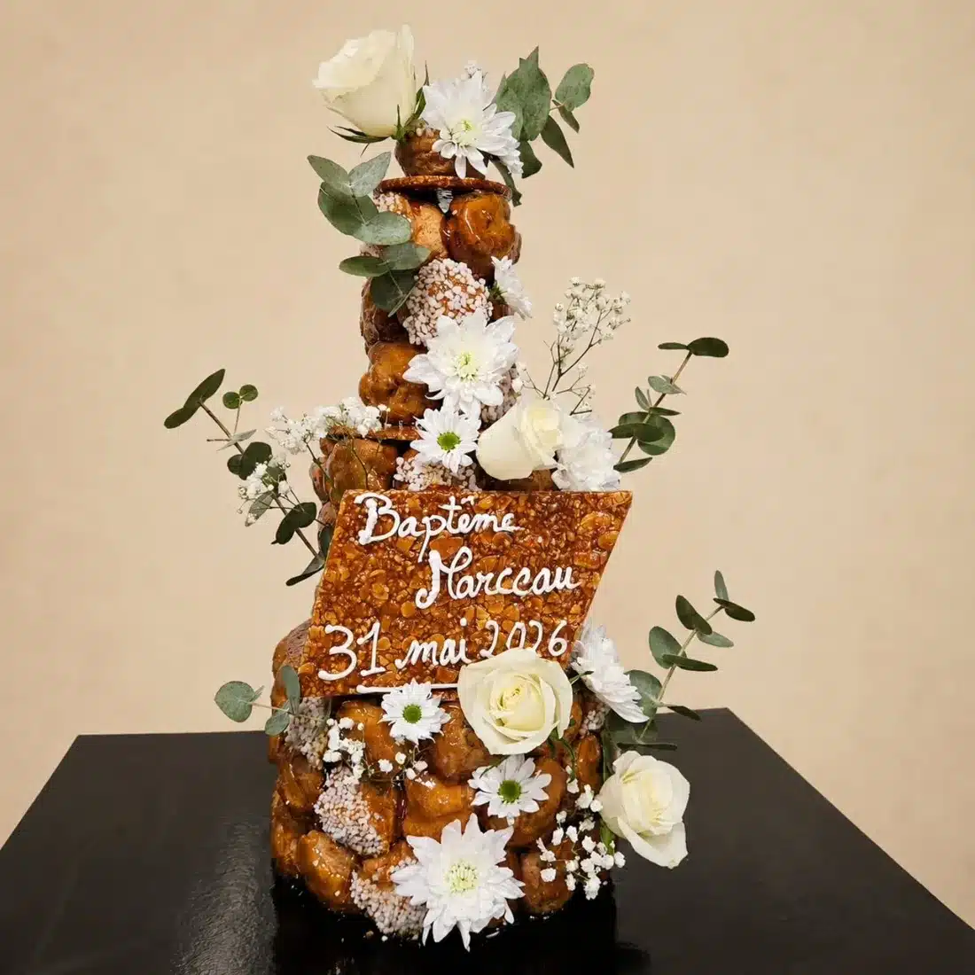 Pyramide de choux pour un baptême, décorée de fleurs blanches