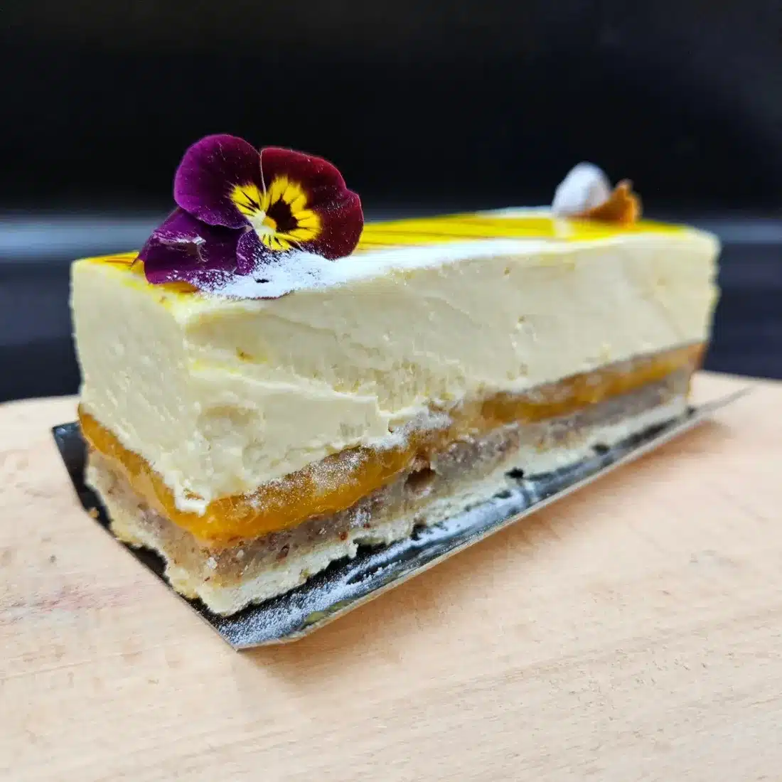 Part d'entremets aux fruits jaunes et fleur comestible
